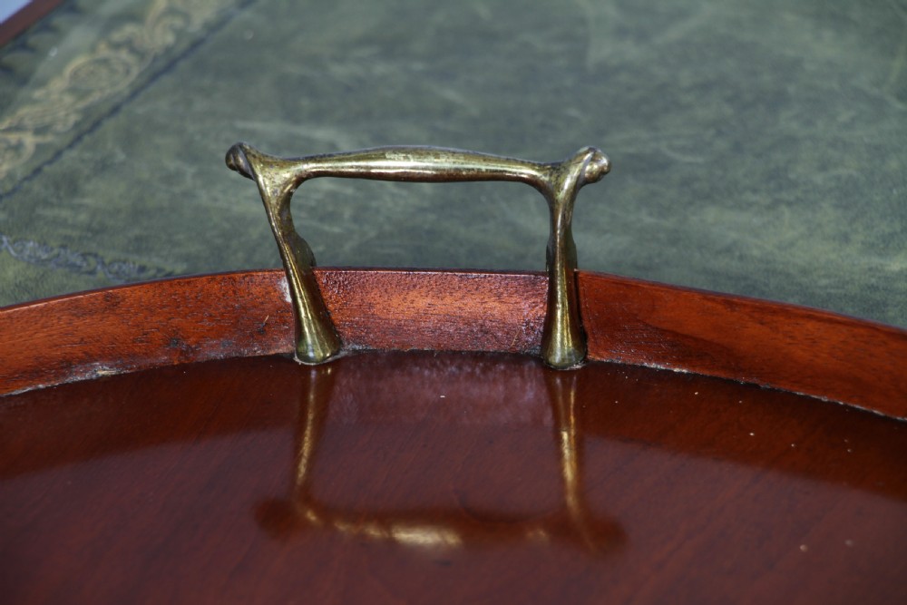 An Edwardian kidney-shaped solid mahogany serving tray featuring a central inlaid shell motif and two brass carrying handles. View IX