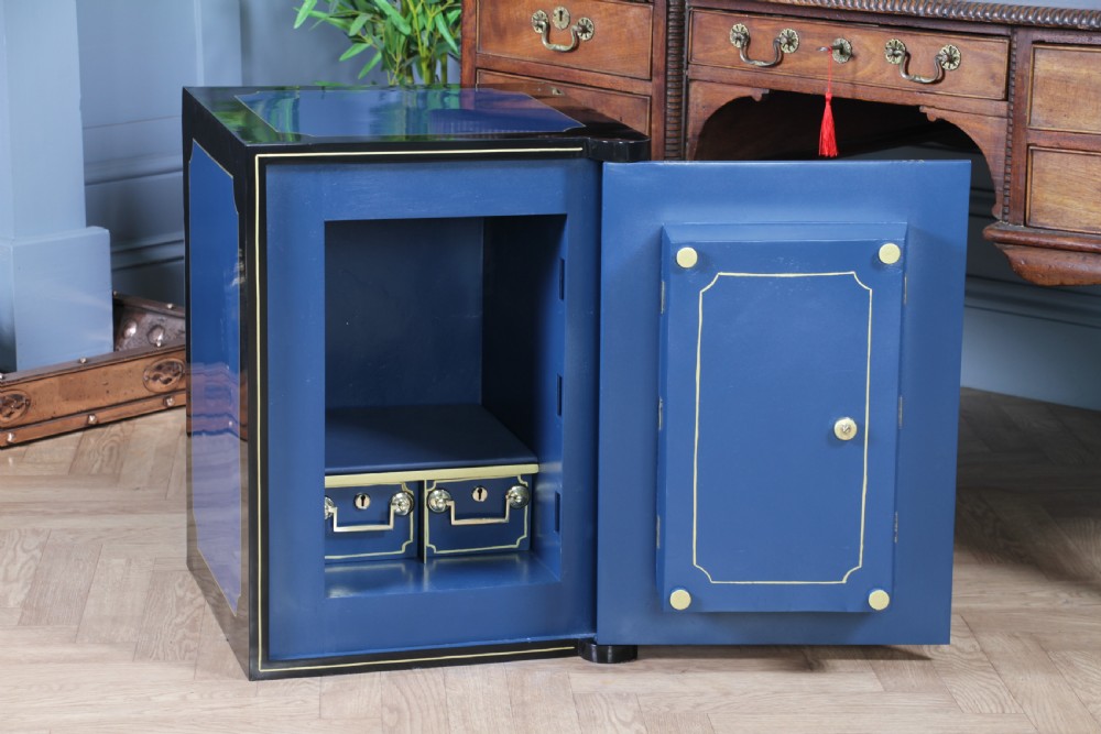A heavy restored Victorian cast iron safe featuring a deep blue and black lacquered exterior with gold pinstriping and a brass royal coat of arms crest. View VI
