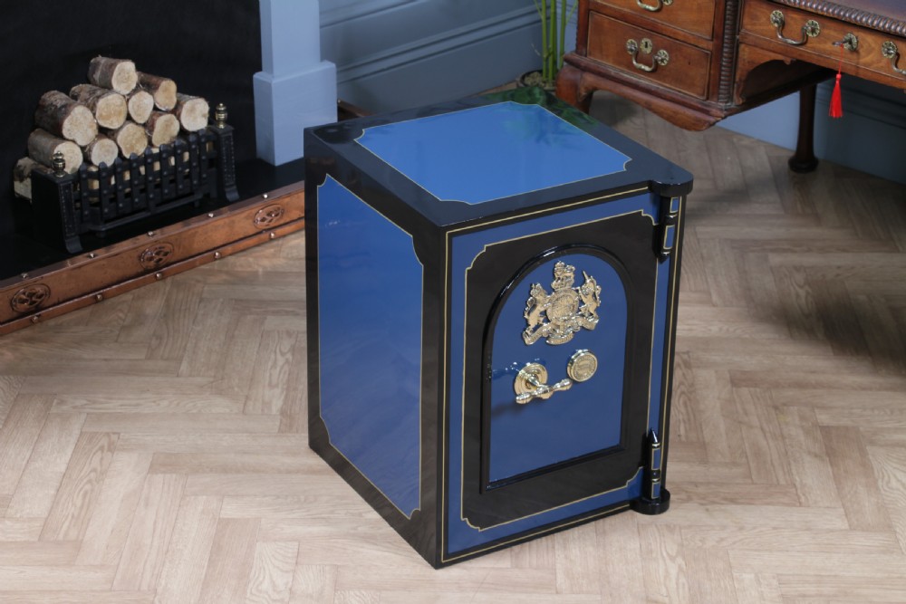 A heavy restored Victorian cast iron safe featuring a deep blue and black lacquered exterior with gold pinstriping and a brass royal coat of arms crest. View VIII