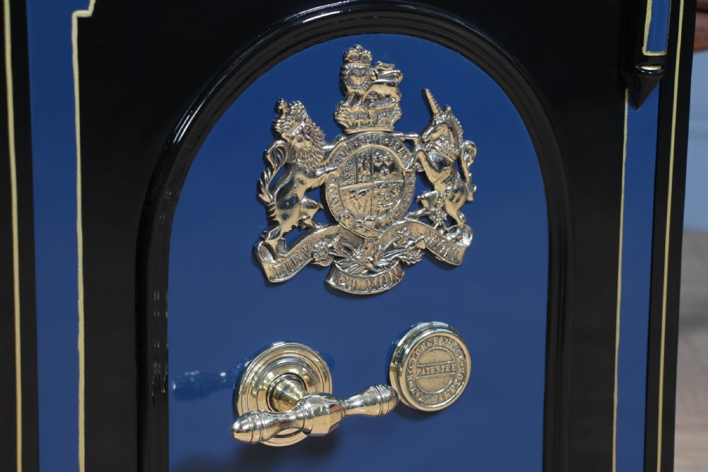 A heavy restored Victorian cast iron safe featuring a deep blue and black lacquered exterior with gold pinstriping and a brass royal coat of arms crest. View XI