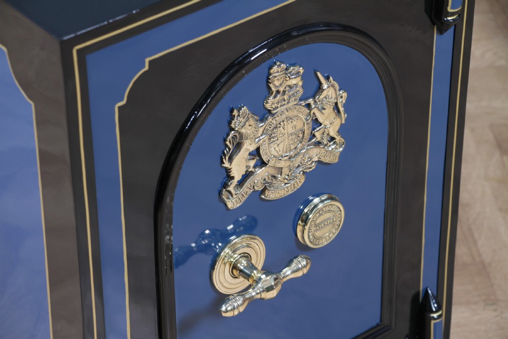 A heavy restored Victorian cast iron safe featuring a deep blue and black lacquered exterior with gold pinstriping and a brass royal coat of arms crest. View XII