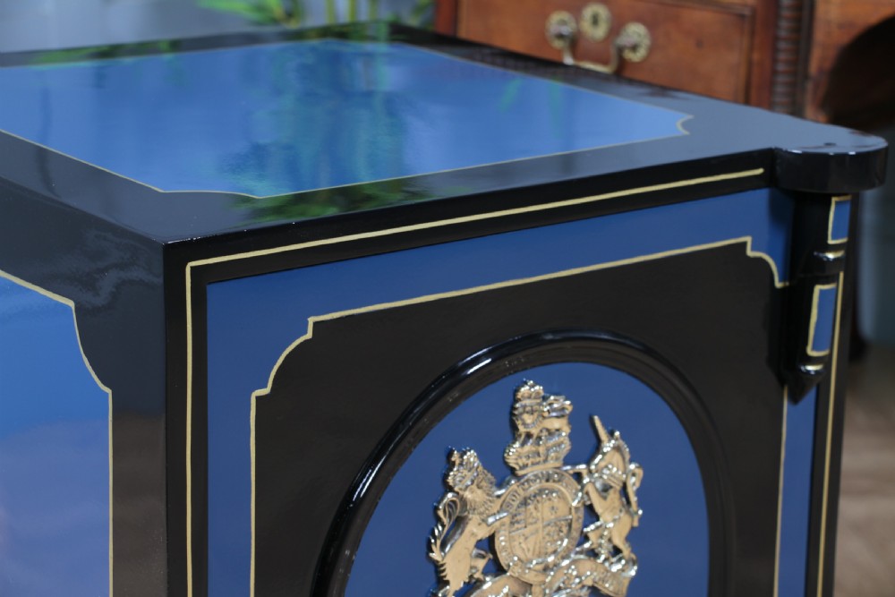 A heavy restored Victorian cast iron safe featuring a deep blue and black lacquered exterior with gold pinstriping and a brass royal coat of arms crest. View XVI
