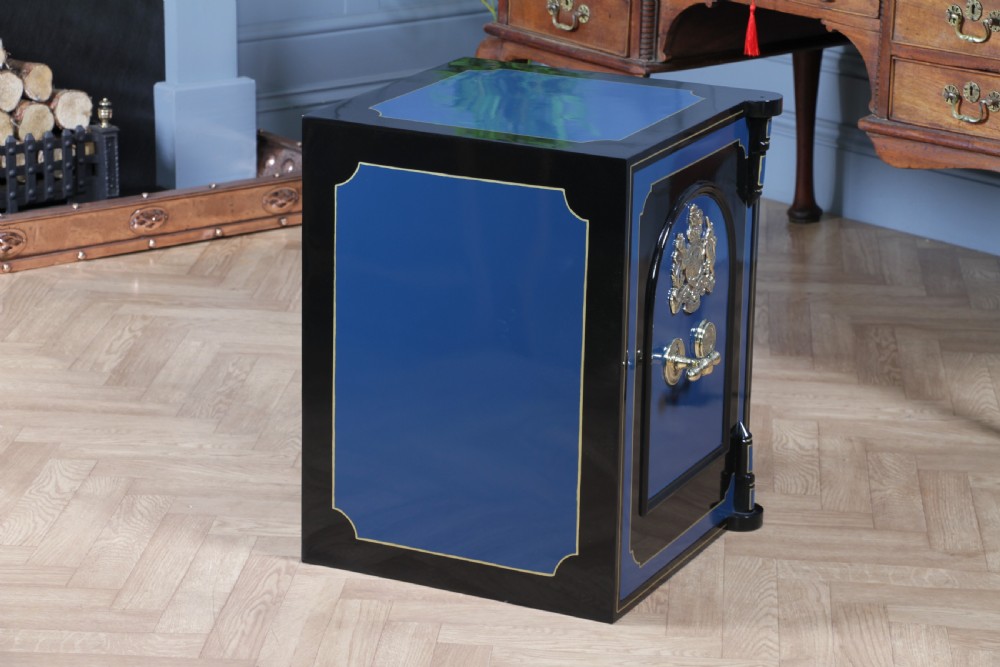A heavy restored Victorian cast iron safe featuring a deep blue and black lacquered exterior with gold pinstriping and a brass royal coat of arms crest. View XVII
