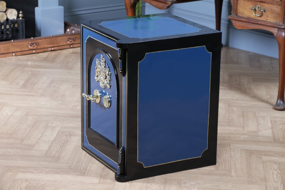 A heavy restored Victorian cast iron safe featuring a deep blue and black lacquered exterior with gold pinstriping and a brass royal coat of arms crest. View XIX