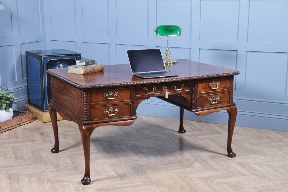 A Georgian mahogany writing desk featuring a rectangular top, central kneehole drawer flanked by side drawers, polished brass handles, and cabriole legs ending in pad feet. View III