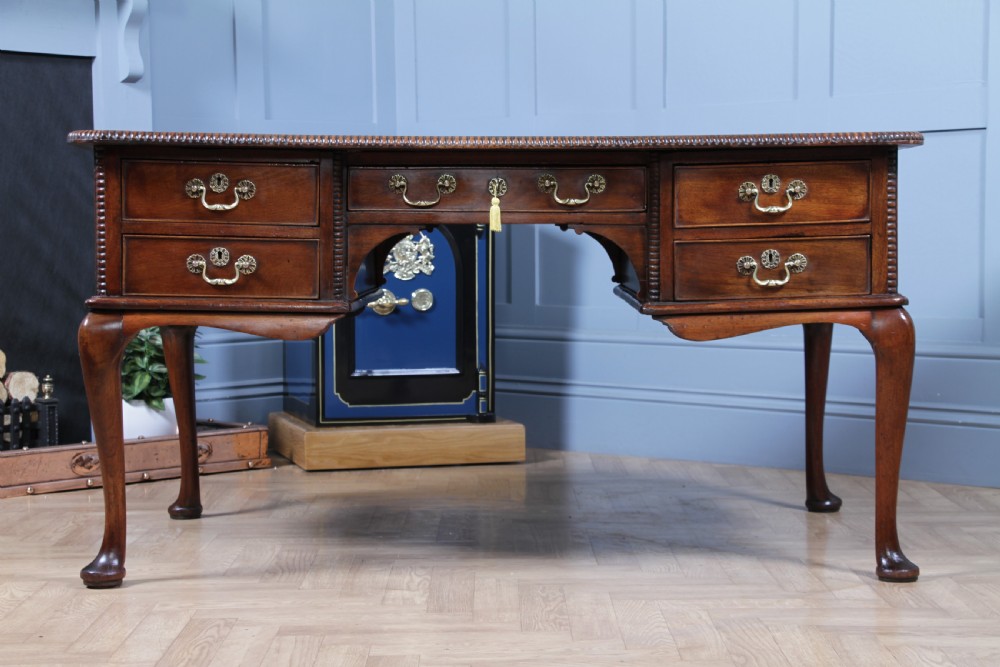 A Georgian mahogany writing desk featuring a rectangular top, central kneehole drawer flanked by side drawers, polished brass handles, and cabriole legs ending in pad feet. View XIII