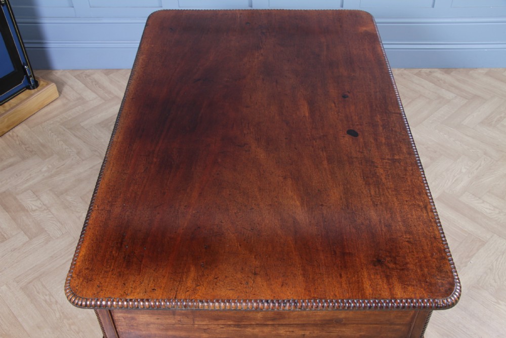 A Georgian mahogany writing desk featuring a rectangular top, central kneehole drawer flanked by side drawers, polished brass handles, and cabriole legs ending in pad feet. View XIV