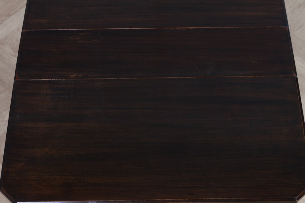An Edwardian solid mahogany Sutherland table with folded drop-leaf sides, turned spindle legs, and ceramic castors on trestle feet. View XVIII