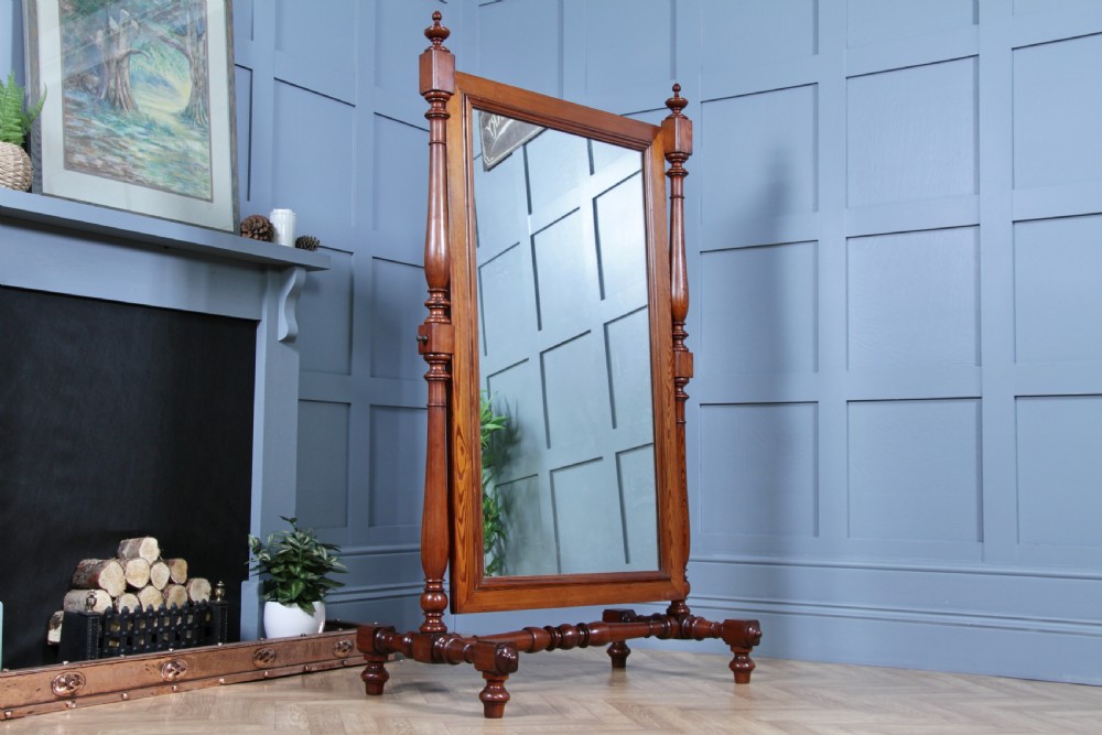 Victorian pitch pine cheval mirror featuring turned upright pillars, decorative finials, and a large tilting glass plate. View II