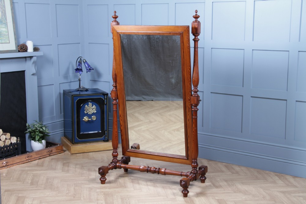 Victorian pitch pine cheval mirror featuring turned upright pillars, decorative finials, and a large tilting glass plate. View IV