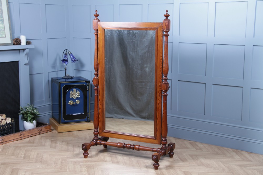 Victorian pitch pine cheval mirror featuring turned upright pillars, decorative finials, and a large tilting glass plate. View V