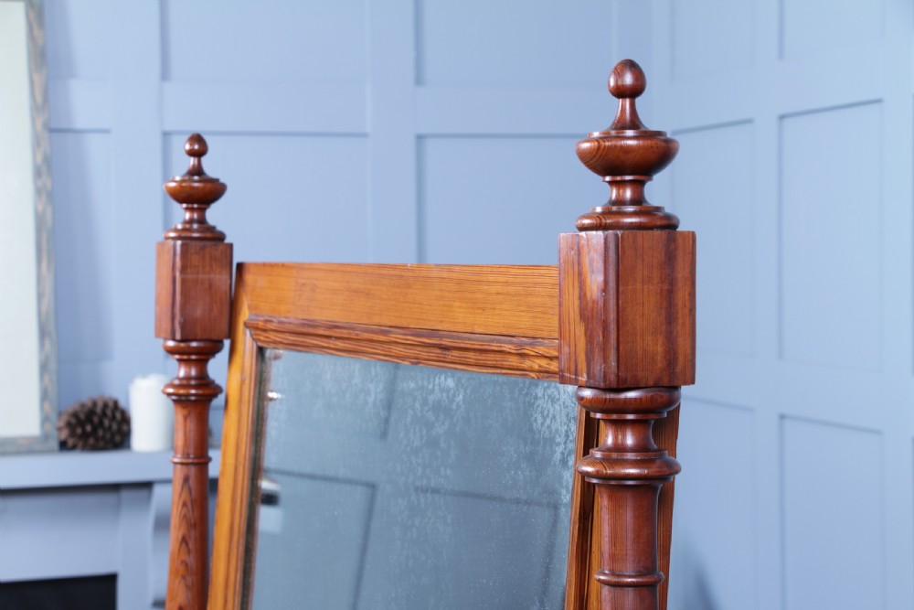 Victorian pitch pine cheval mirror featuring turned upright pillars, decorative finials, and a large tilting glass plate. View VI