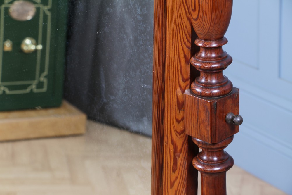 Victorian pitch pine cheval mirror featuring turned upright pillars, decorative finials, and a large tilting glass plate. View VII