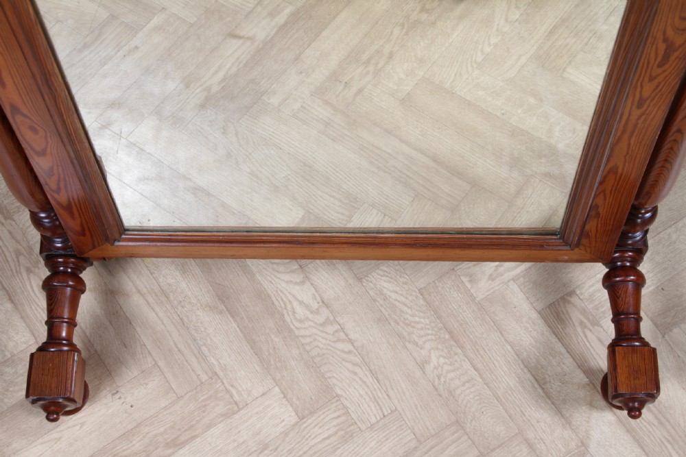 Victorian pitch pine cheval mirror featuring turned upright pillars, decorative finials, and a large tilting glass plate. View IX