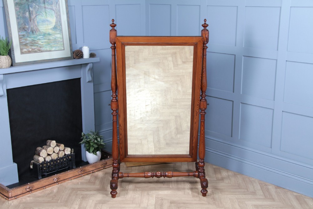 Victorian pitch pine cheval mirror featuring turned upright pillars, decorative finials, and a large tilting glass plate. View XV