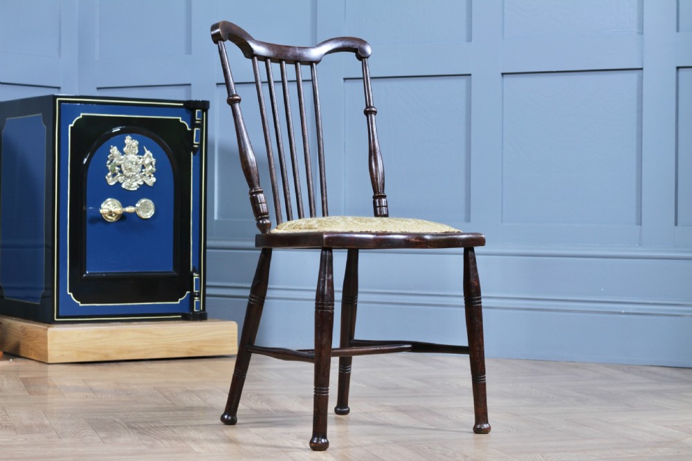 An Edwardian dark walnut nursing chair featuring a spindled stick back, turned legs, and a patterned yellow fabric seat. View II