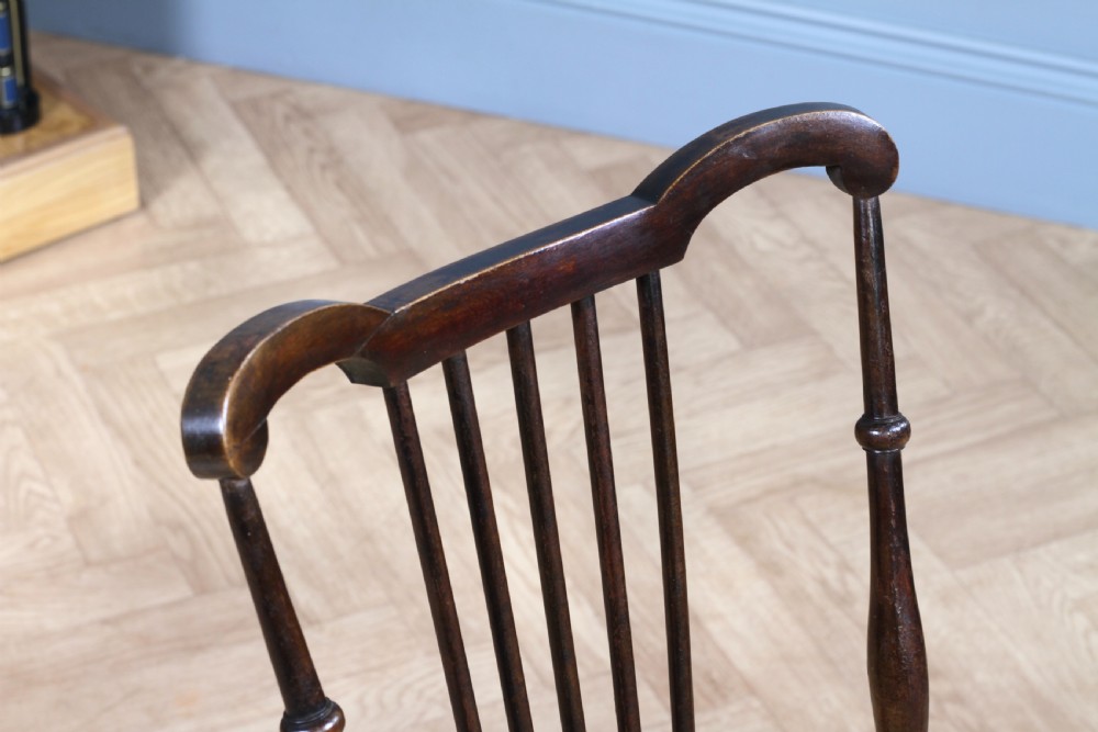 An Edwardian dark walnut nursing chair featuring a spindled stick back, turned legs, and a patterned yellow fabric seat. View V