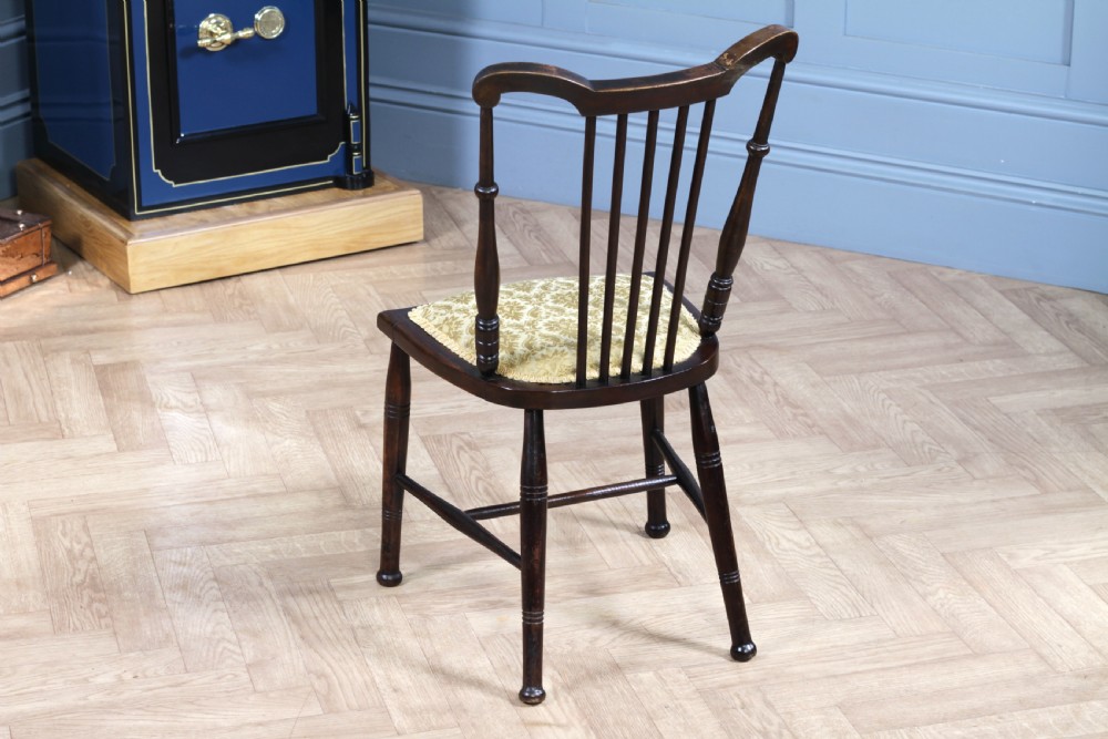 An Edwardian dark walnut nursing chair featuring a spindled stick back, turned legs, and a patterned yellow fabric seat. View VI