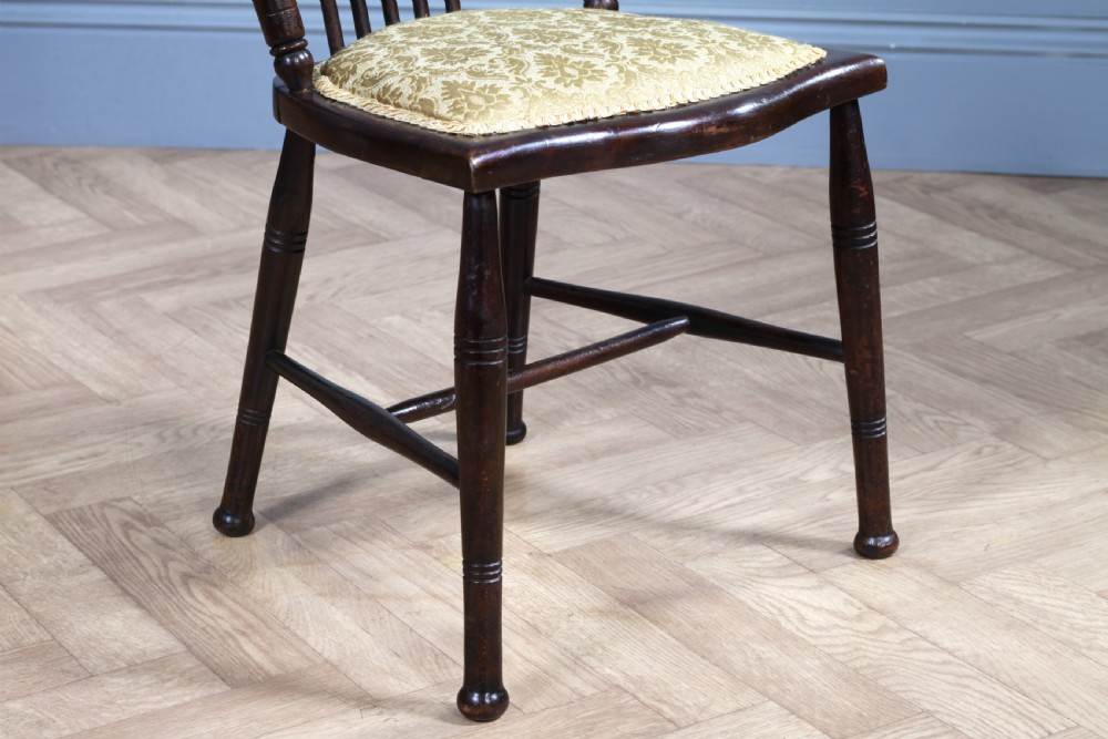 An Edwardian dark walnut nursing chair featuring a spindled stick back, turned legs, and a patterned yellow fabric seat. View VIII