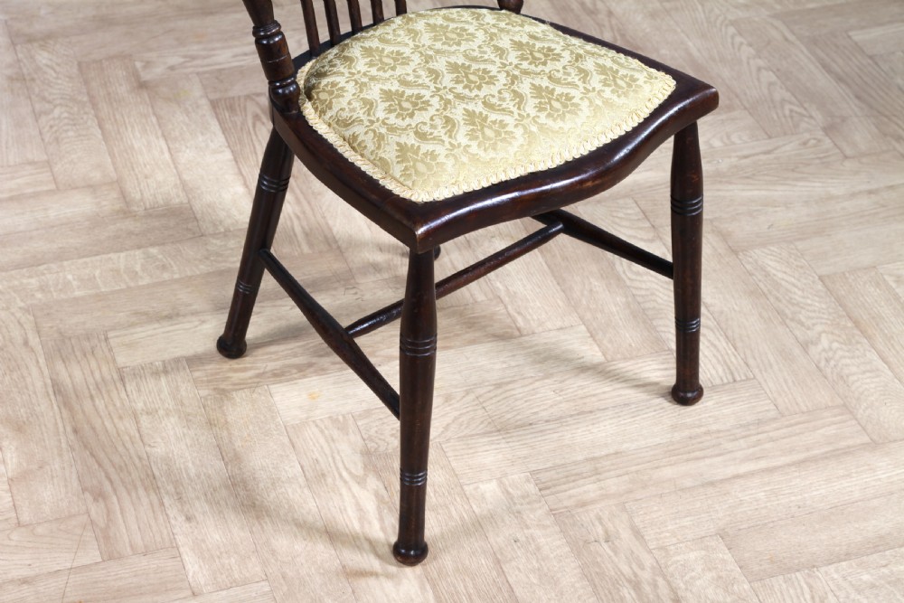 An Edwardian dark walnut nursing chair featuring a spindled stick back, turned legs, and a patterned yellow fabric seat. View XI