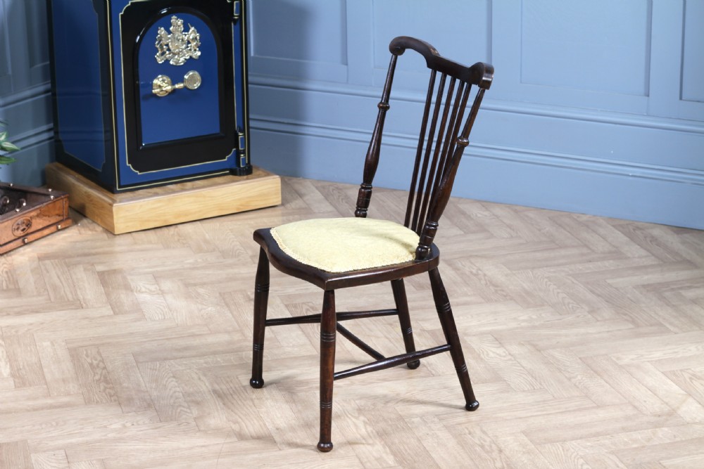 An Edwardian dark walnut nursing chair featuring a spindled stick back, turned legs, and a patterned yellow fabric seat. View XII
