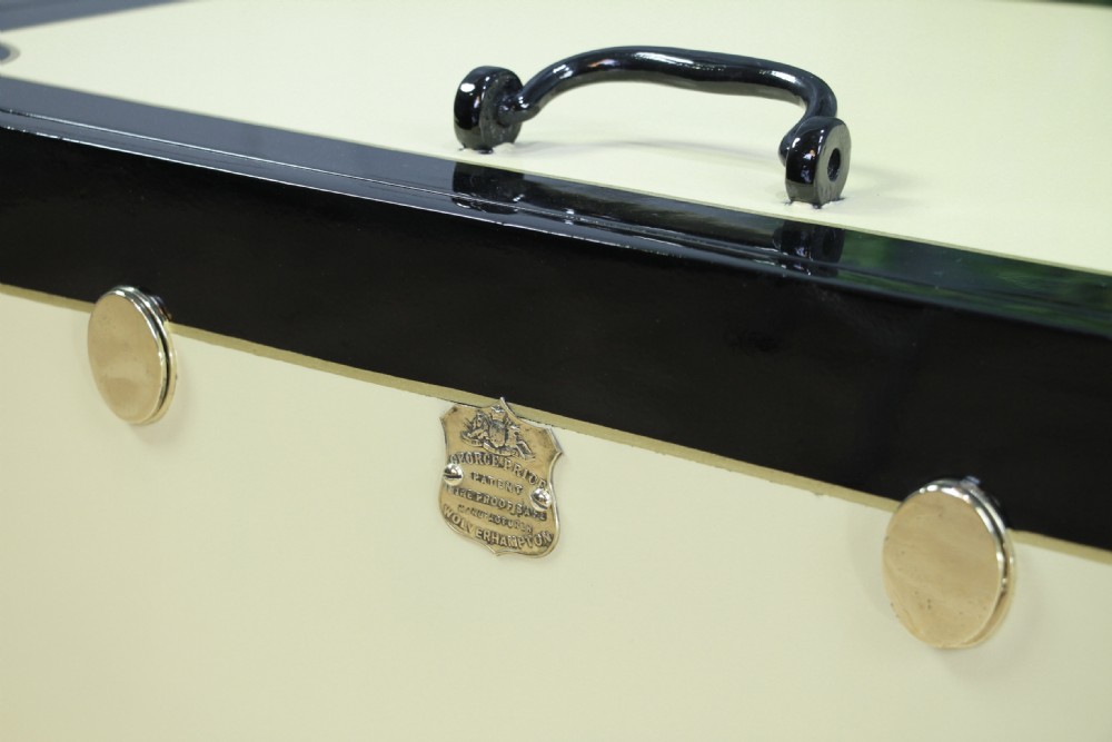 A restored Victorian George Price iron strong box with black painted edges, cream center panels, heavy iron handles, and a brass makers plaque. View X