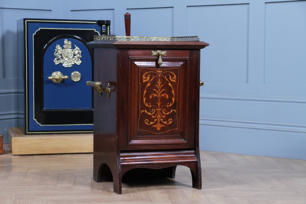 An Edwardian dark mahogany coal purdonium featuring classical floral marquetry inlay, side carry handles, a pierced brass top gallery, and a rear wooden shovel handle. View V