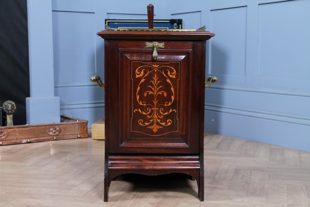 An Edwardian dark mahogany coal purdonium featuring classical floral marquetry inlay, side carry handles, a pierced brass top gallery, and a rear wooden shovel handle. View VI