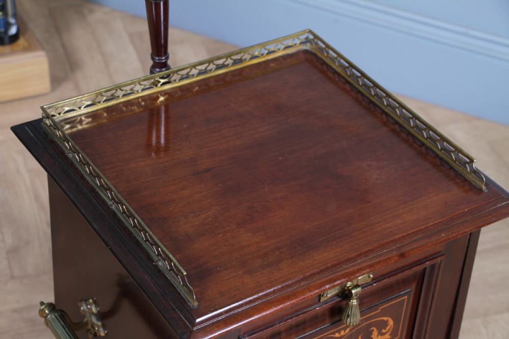An Edwardian dark mahogany coal purdonium featuring classical floral marquetry inlay, side carry handles, a pierced brass top gallery, and a rear wooden shovel handle. View IX
