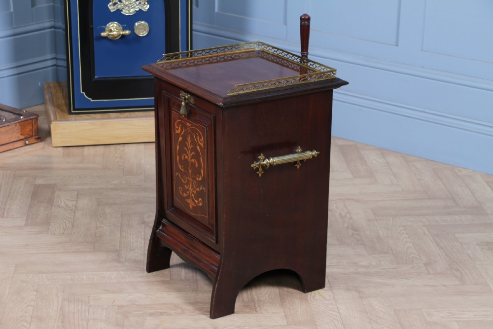 An Edwardian dark mahogany coal purdonium featuring classical floral marquetry inlay, side carry handles, a pierced brass top gallery, and a rear wooden shovel handle. View XIV