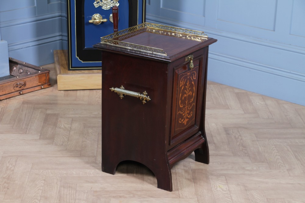 An Edwardian dark mahogany coal purdonium featuring classical floral marquetry inlay, side carry handles, a pierced brass top gallery, and a rear wooden shovel handle. View XV