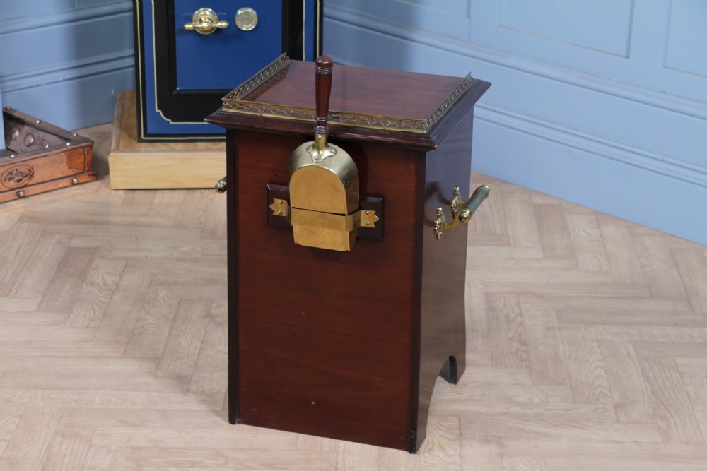 An Edwardian dark mahogany coal purdonium featuring classical floral marquetry inlay, side carry handles, a pierced brass top gallery, and a rear wooden shovel handle. View XVI