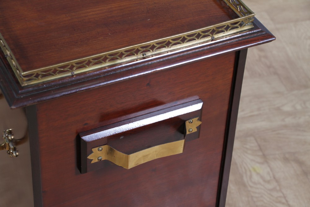 An Edwardian dark mahogany coal purdonium featuring classical floral marquetry inlay, side carry handles, a pierced brass top gallery, and a rear wooden shovel handle. View XXI
