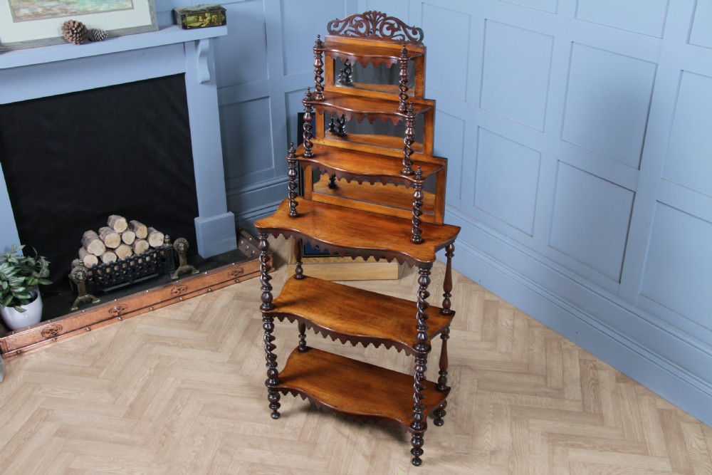A Victorian six-tier walnut whatnot display shelf featuring hollow barley twist columns, mirrored back panels, and carved fretwork cresting. View III