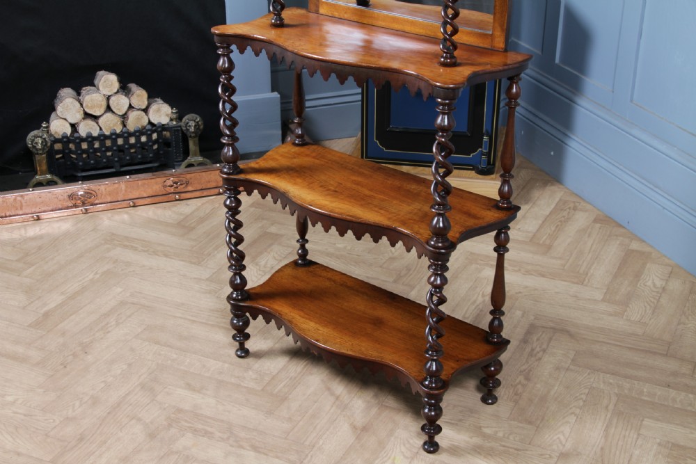 A Victorian six-tier walnut whatnot display shelf featuring hollow barley twist columns, mirrored back panels, and carved fretwork cresting. View VII