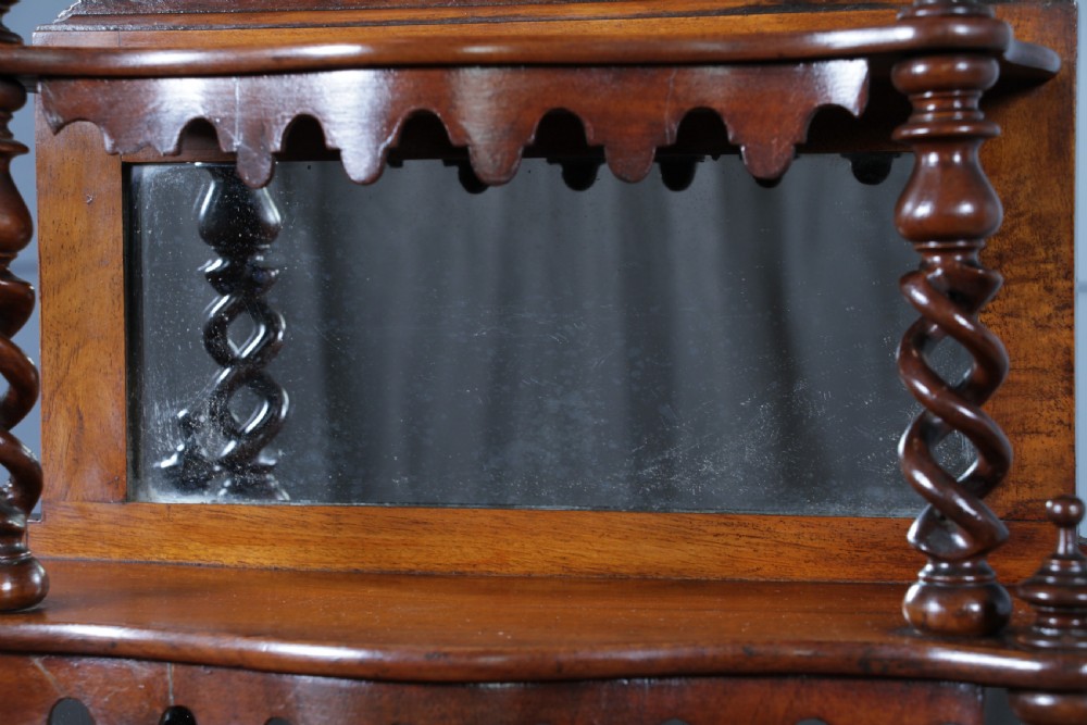 A Victorian six-tier walnut whatnot display shelf featuring hollow barley twist columns, mirrored back panels, and carved fretwork cresting. View IX