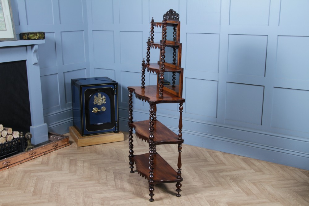 A Victorian six-tier walnut whatnot display shelf featuring hollow barley twist columns, mirrored back panels, and carved fretwork cresting. View X