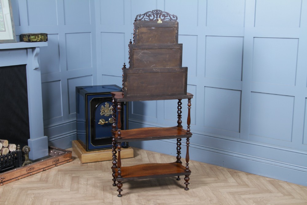 A Victorian six-tier walnut whatnot display shelf featuring hollow barley twist columns, mirrored back panels, and carved fretwork cresting. View XI