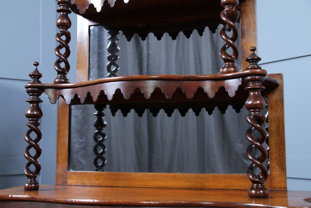 A Victorian six-tier walnut whatnot display shelf featuring hollow barley twist columns, mirrored back panels, and carved fretwork cresting. View XIII