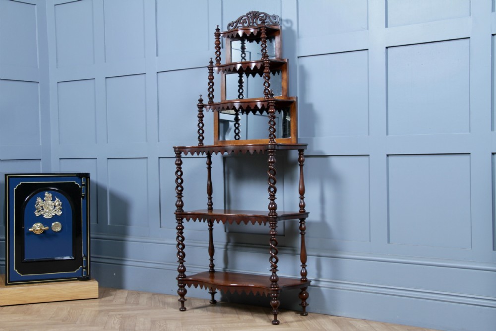 A Victorian six-tier walnut whatnot display shelf featuring hollow barley twist columns, mirrored back panels, and carved fretwork cresting. View XXII