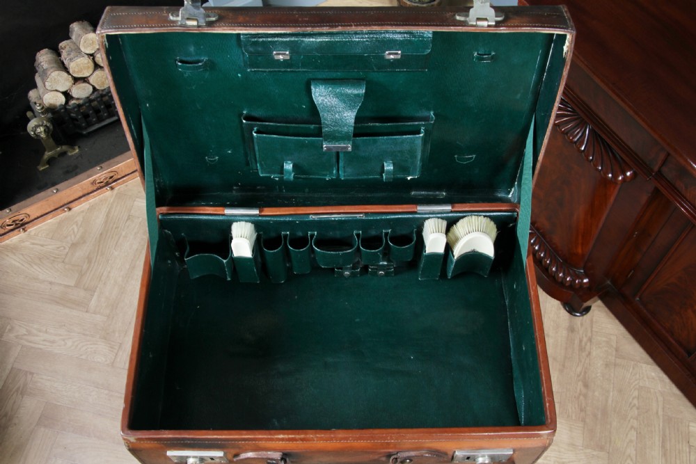 A rectangular chestnut brown leather suitcase with brass slide latches, a central leather handle, and black stencilled lettering reading C. ANTROBUS. View XVI