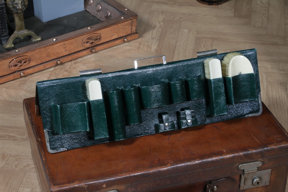 A rectangular chestnut brown leather suitcase with brass slide latches, a central leather handle, and black stencilled lettering reading C. ANTROBUS. View XXV