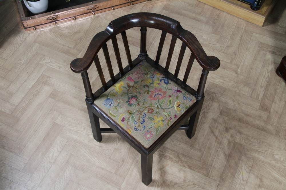 A dark elm Georgian corner chair with a curved top rail, slat back structure, turned supports, cross stretchers, and a floral tapestry drop-in seat. View II