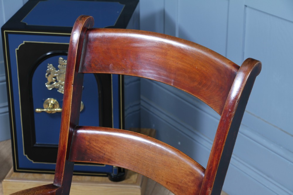 An antique Victorian ladder-back wooden rocking chair with three horizontal back slats, turned spindle arm supports, and curved rockers. View VIII
