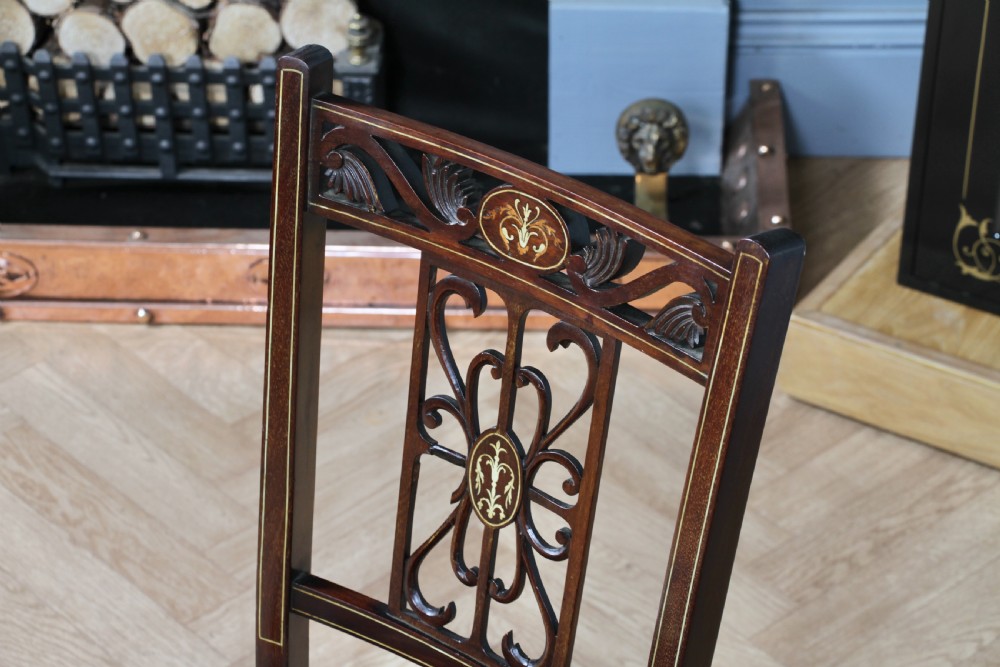 An Edwardian mahogany nursing chair featuring an inlaid pierced back splat, decorative stringing, and a black silk upholstered seat with embroidered floral motifs. View IV