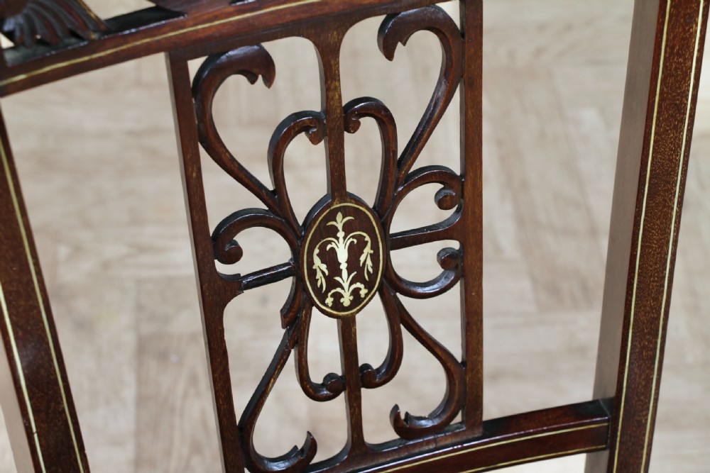 An Edwardian mahogany nursing chair featuring an inlaid pierced back splat, decorative stringing, and a black silk upholstered seat with embroidered floral motifs. View VI