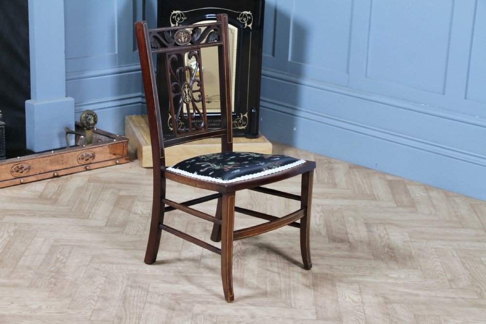 An Edwardian mahogany nursing chair featuring an inlaid pierced back splat, decorative stringing, and a black silk upholstered seat with embroidered floral motifs. View XII