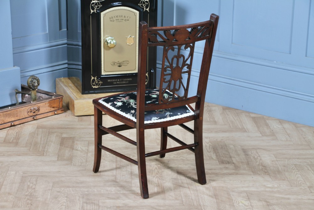 An Edwardian mahogany nursing chair featuring an inlaid pierced back splat, decorative stringing, and a black silk upholstered seat with embroidered floral motifs. View XIII