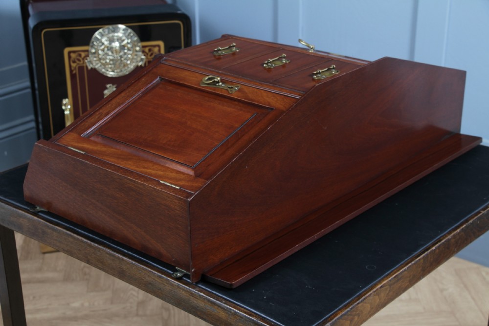 A small Edwardian mahogany wall hanging cabinet featuring two outer cupboards, three central drawers, brass handles, and a low back gallery. View XXII