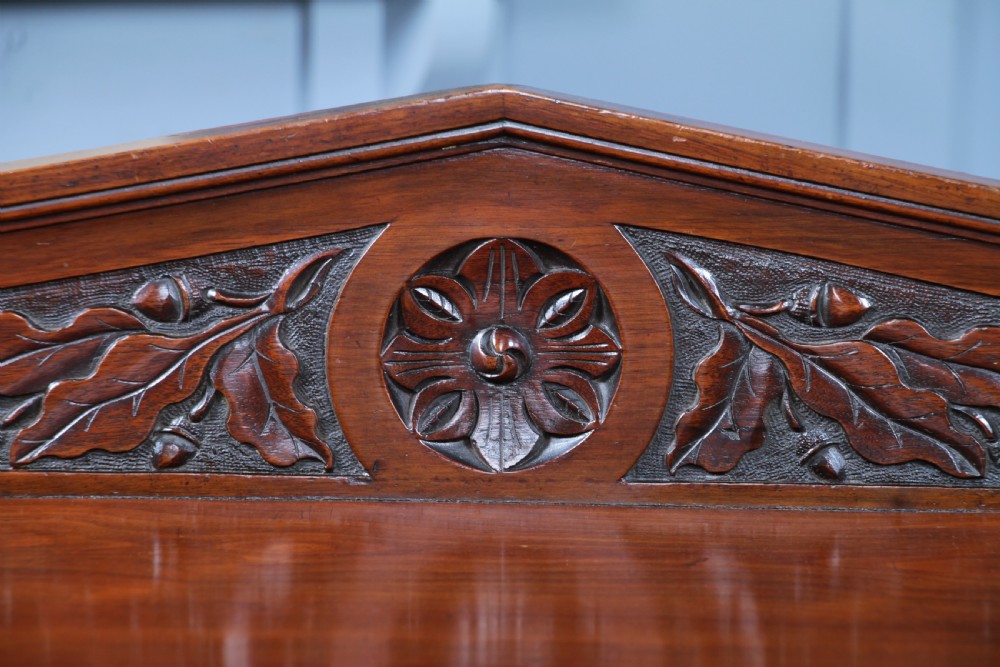A three-tier Victorian walnut dumb waiter featuring turned columns, carved pediment gallery, two central drawers with brass handles, and brass castors. View XIII